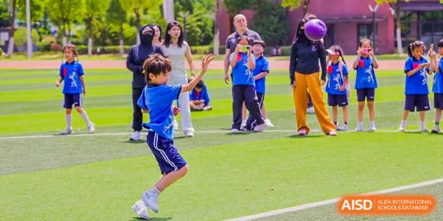 A student from Shanghai United International School Hefei Campus running on a grassy sports field.
