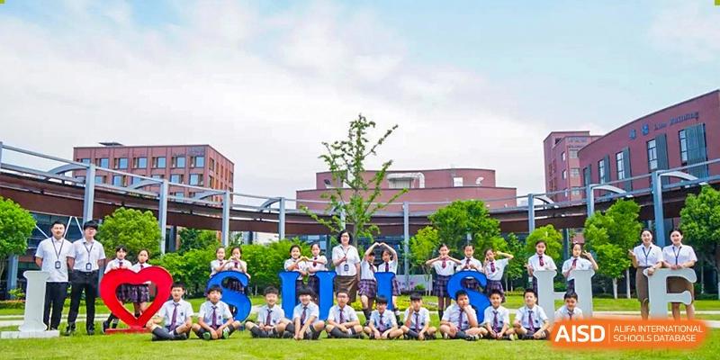 Students from Shanghai United International School Hefei Campus posing for a group photo in front of the school building.