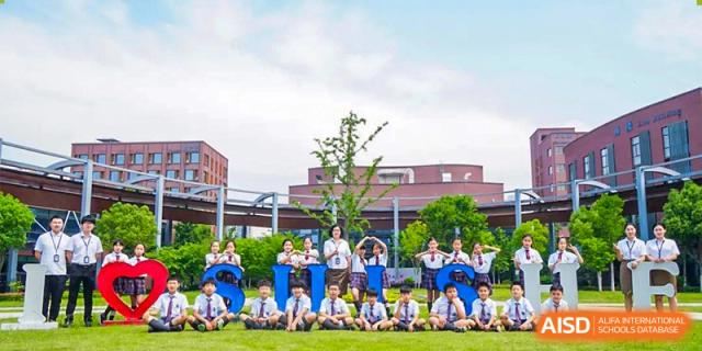 Students from Shanghai United International School Hefei Campus posing for a group photo in front of the school building.