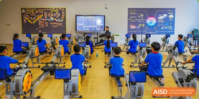 Students from Shanghai United International School Hefei Campus using indoor rowing machines in a fitness class.