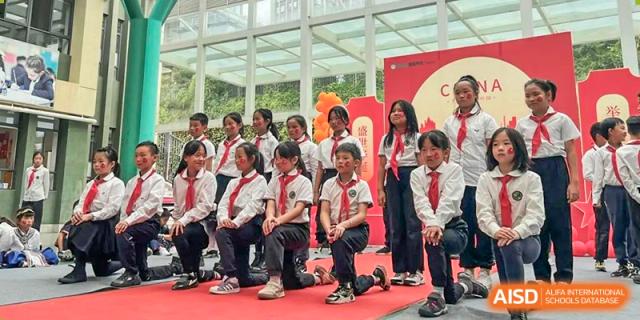 A group of students from Beanstalk International Bilingual School Kunming dressed in uniform and posing in a performance or formal group setting.