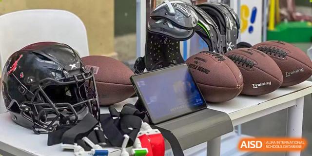 Beanstalk International Bilingual School Kunming sports equipment including a football, helmet, gloves, and an open tablet device.