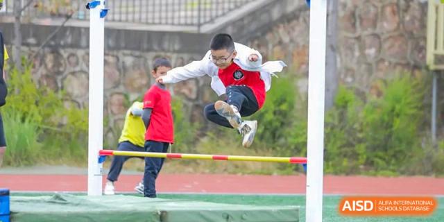 A student from Beanstalk International Bilingual School Kunming successfully clearing the bar during a high jump competition.