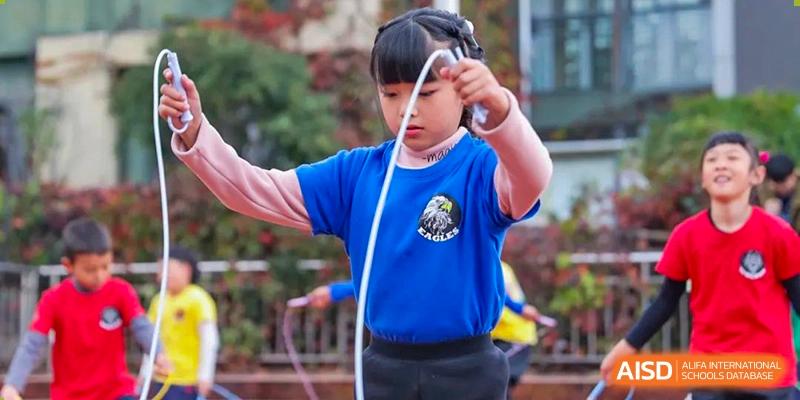 A young female student from Beanstalk International Bilingual School Kunming holding a jump rope and preparing to skip.