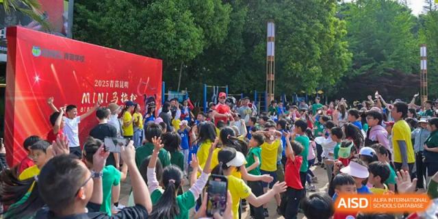 A large, energetic crowd of students and faculty from Beanstalk International Bilingual School Kunming participating in an outdoor sports or school event.