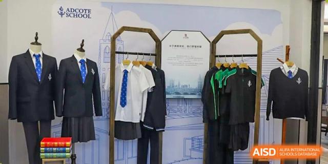 Two students' uniforms from Adcote School Shanghai are displayed on mannequins, with a tie and blazer.