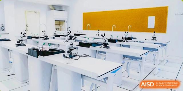 A science lab at Adcote School Shanghai with white desks and microscopes ready for a class.