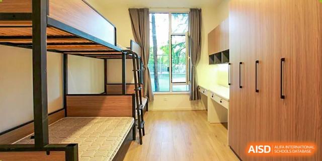 The interior of a student dormitory room at Adcote School Shanghai, with bunk beds and a desk.