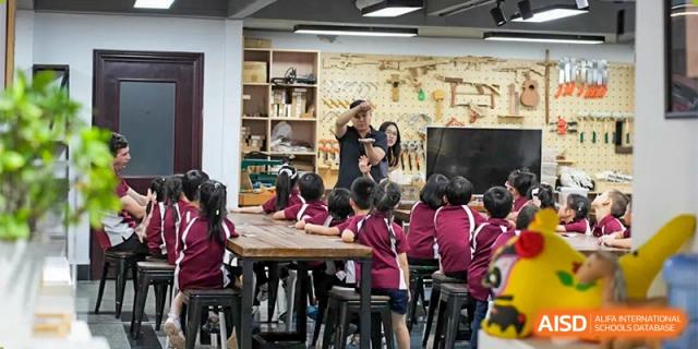 A teacher talking to a group of students sitting at a table in a classroom at Bromsgrove School Mission Hills.
