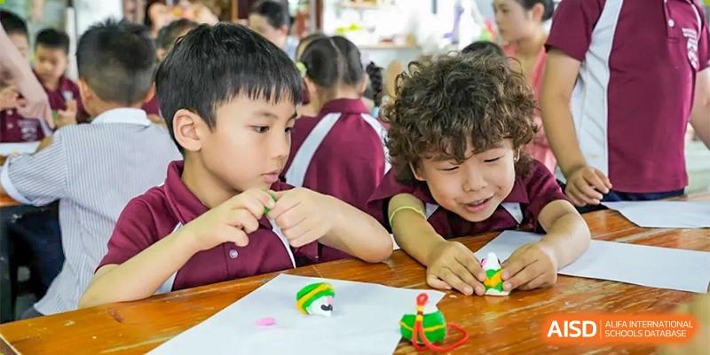 Two students at Bromsgrove School Mission Hills focused on a craft project at a table.