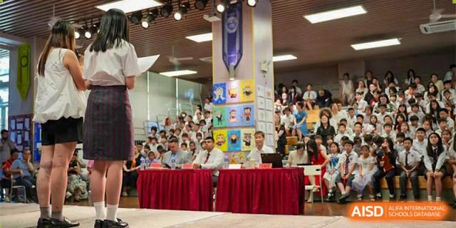 A large group of students and teachers gathered in a hall for a school event at Bromsgrove School Mission Hills.