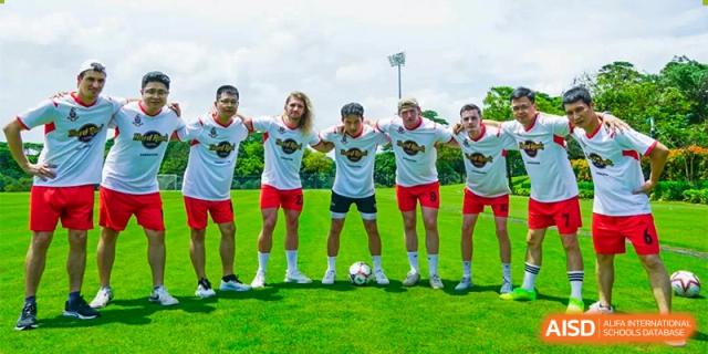 A soccer team of girls in white jerseys posing for a photo on the field at Bromsgrove School Mission Hills.
