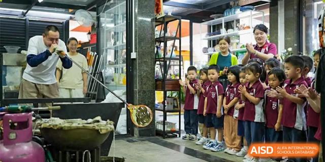 A group of young Bromsgrove School Mission Hills students looking at an educational display inside a building.