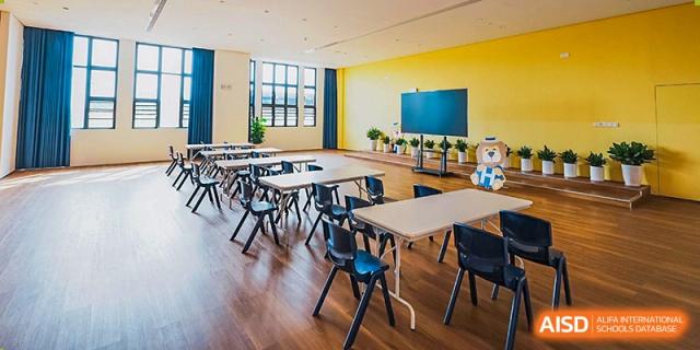 The brightly lit, modern classroom interior at Harrow Lide High School Nanning, featuring desks and a large screen.