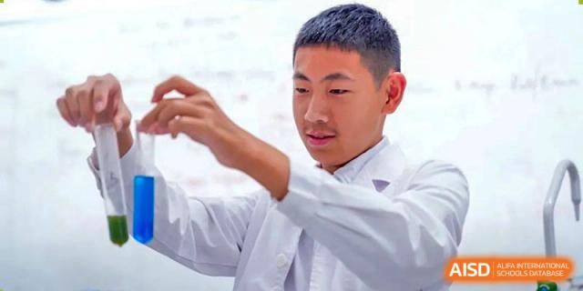 A Harrow Lide High School Nanning student in a white lab coat conducting an experiment or demonstration in a science lab.