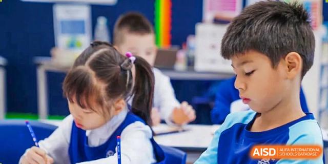 Close-up of Harrow Lide High School Nanning primary students working quietly on a task at their desks in class.