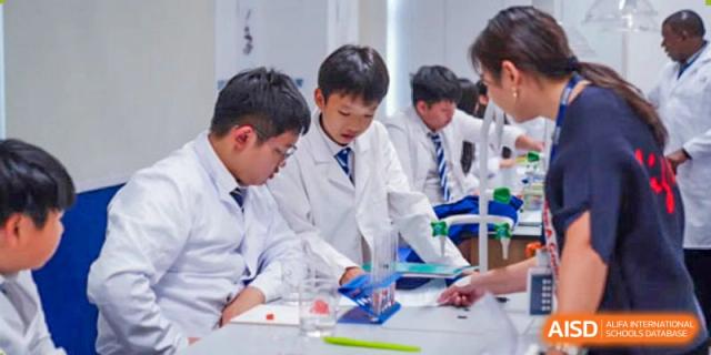 Harrow Lide High School Nanning students in lab coats collaborating on a hands-on science project or experiment.