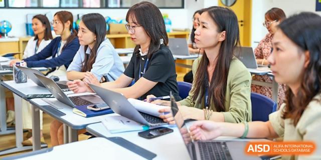 Harrow Lide High School Nanning students and staff working on laptops and tablets during an intensive session.