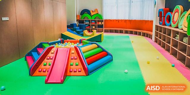 Indoor soft play area with colorful climbing structures, slides, and a ball pit, at Harrow Lide High School Nanning.