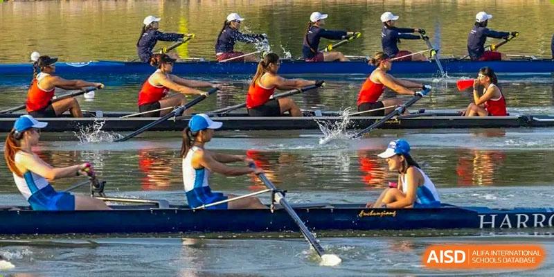 Rowers in a boat practicing on the water, with synchronized oars splashing, representing the rowing team of Harrow Lide High School Nanning.