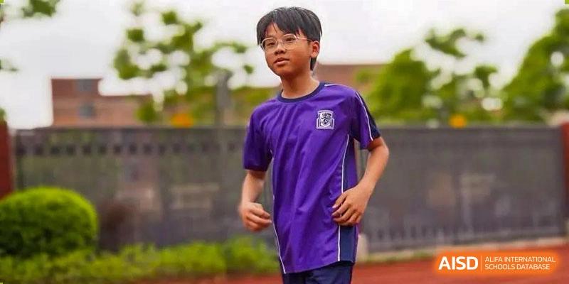 A student wearing a purple sports uniform and glasses running outdoors at Harrow Lide High School Nanning.