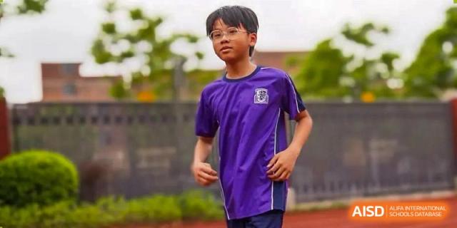 A student wearing a purple sports uniform and glasses running outdoors at Harrow Lide High School Nanning.