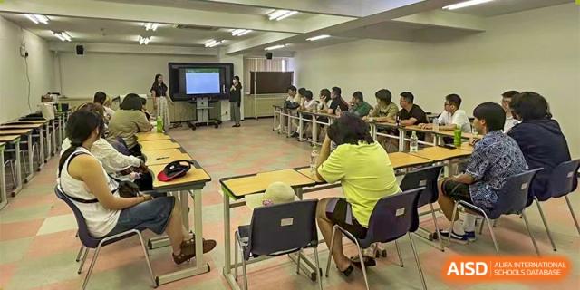 Students are seated at desks in a classroom, with a projector screen visible in the background, during a lesson at Guokai International School of Qingdao.