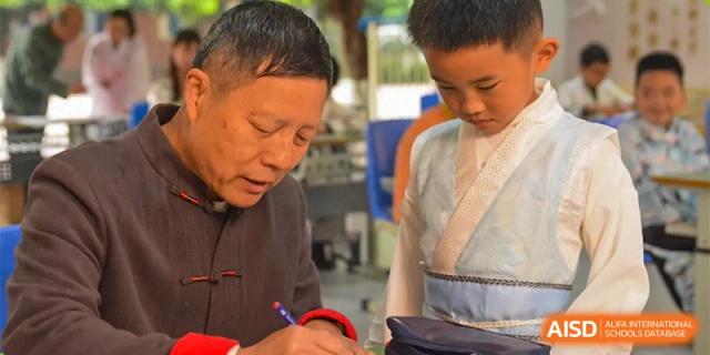An adult is helping a student with his schoolwork at Chengdu Meishi International School.