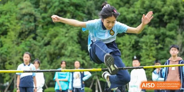 A male student is in the air, participating in a high jump competition at Chengdu Meishi International School.