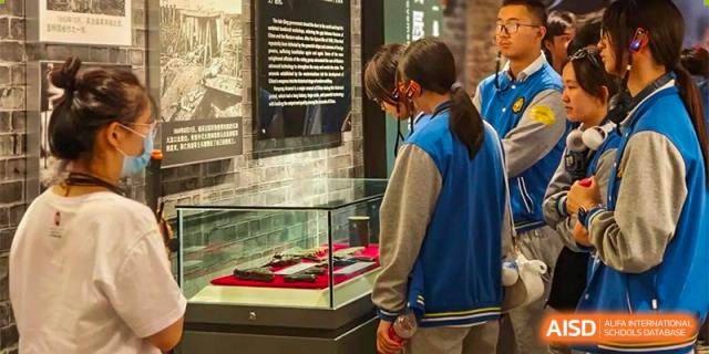 A student is looking at a trophy on display in a glass case at Chengdu Meishi International School.