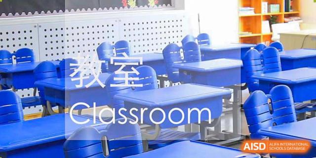 An empty classroom at Qingdao Cornerstone Bilingual School with blue desks and chairs.