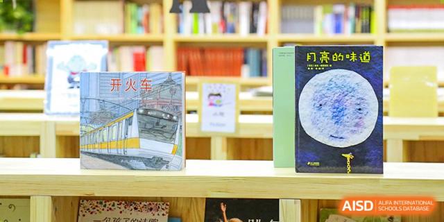 A close-up of books on a bookshelf in the library at Qingdao Cornerstone Bilingual School.