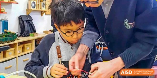 A student from Qingdao Cornerstone Bilingual School focused on a hands-on building project.