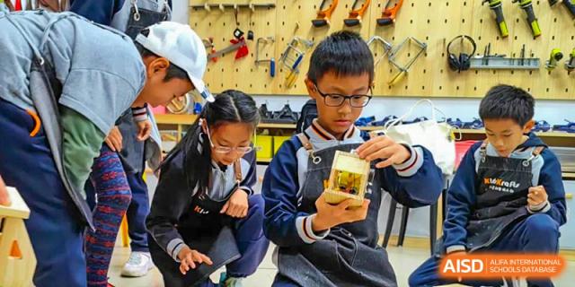 Qingdao Cornerstone Bilingual School students collaborating on a building project.