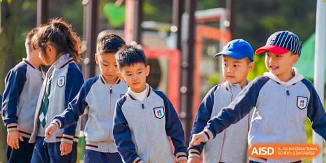 Qingdao Cornerstone Bilingual School students walking together outdoors during a field trip or an event.