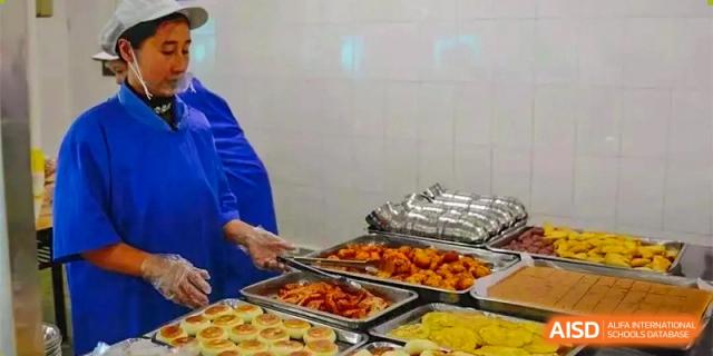 A student is holding a tray filled with various dishes at Chengdu Meishi International School.