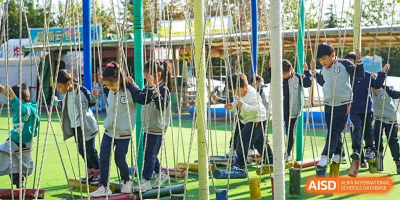 Qingdao Cornerstone Bilingual School students playing on the outdoor playground.