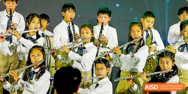 Qingdao Cornerstone Bilingual School students playing in a band with flutes and clarinets.
