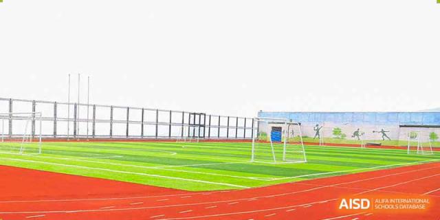 The outdoor sports field at Qingdao Cornerstone Bilingual School with a running track and a soccer goal.