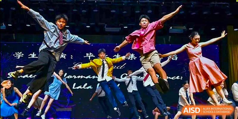 Students from Tsinglan School performing a dance routine on a stage with a purple background.