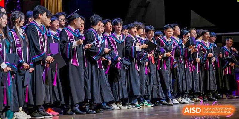 A group of students from Tsinglan School, dressed in graduation gowns, posing for a photo on a stage.