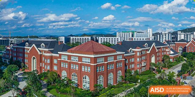 A wide shot of the red brick buildings and campus of Tsinglan School on a clear day.