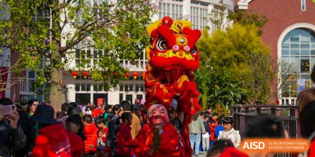 Students from Tsinglan School performing a traditional lion dance at a school event.