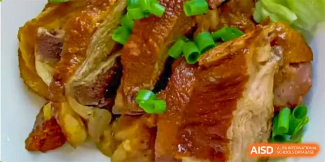 A close-up shot of cooked meat with green onions, served at the cafeteria at Tsinglan School.