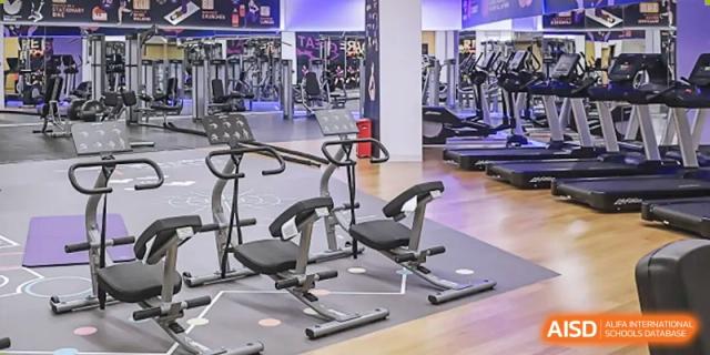 The empty weight room and fitness center at Tsinglan School, showing various exercise machines.