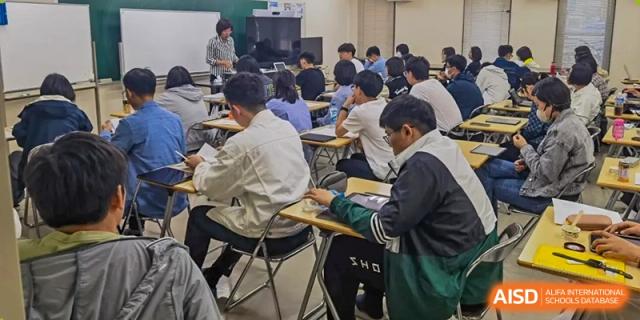 Students from Northeast Yucai Foreign Language School are sitting at their desks, studying and working in a classroom.