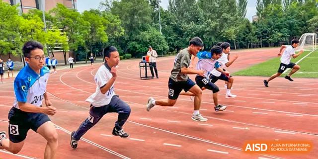 A few students from Northeast Yucai Foreign Language School are running a race on a track.