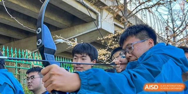 Students from Northeast Yucai Foreign Language School are playing a bow-and-arrow game.