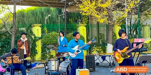 A rock band performs outdoors at an event for Northeast Yucai Foreign Language School.