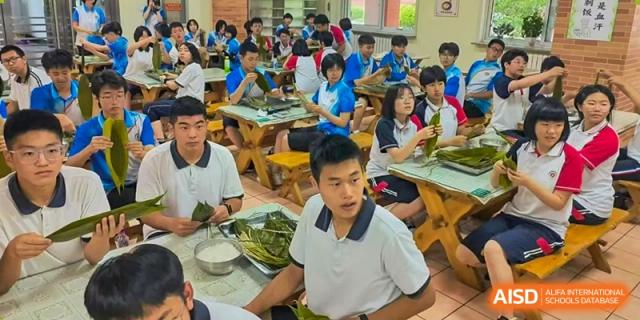 Students from Northeast Yucai Foreign Language School are learning to prepare food in a classroom setting.